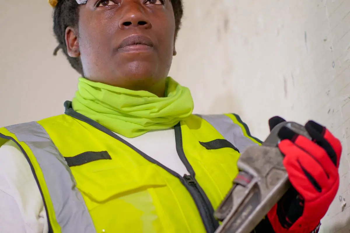 Free A professional female plumber wearing protective gear, ready for work indoors. Stock Photo