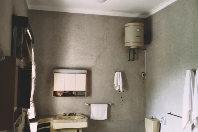 Free A vintage bathroom featuring a bathtub, sink, toilet, and cabinets in muted tones. Stock Photo