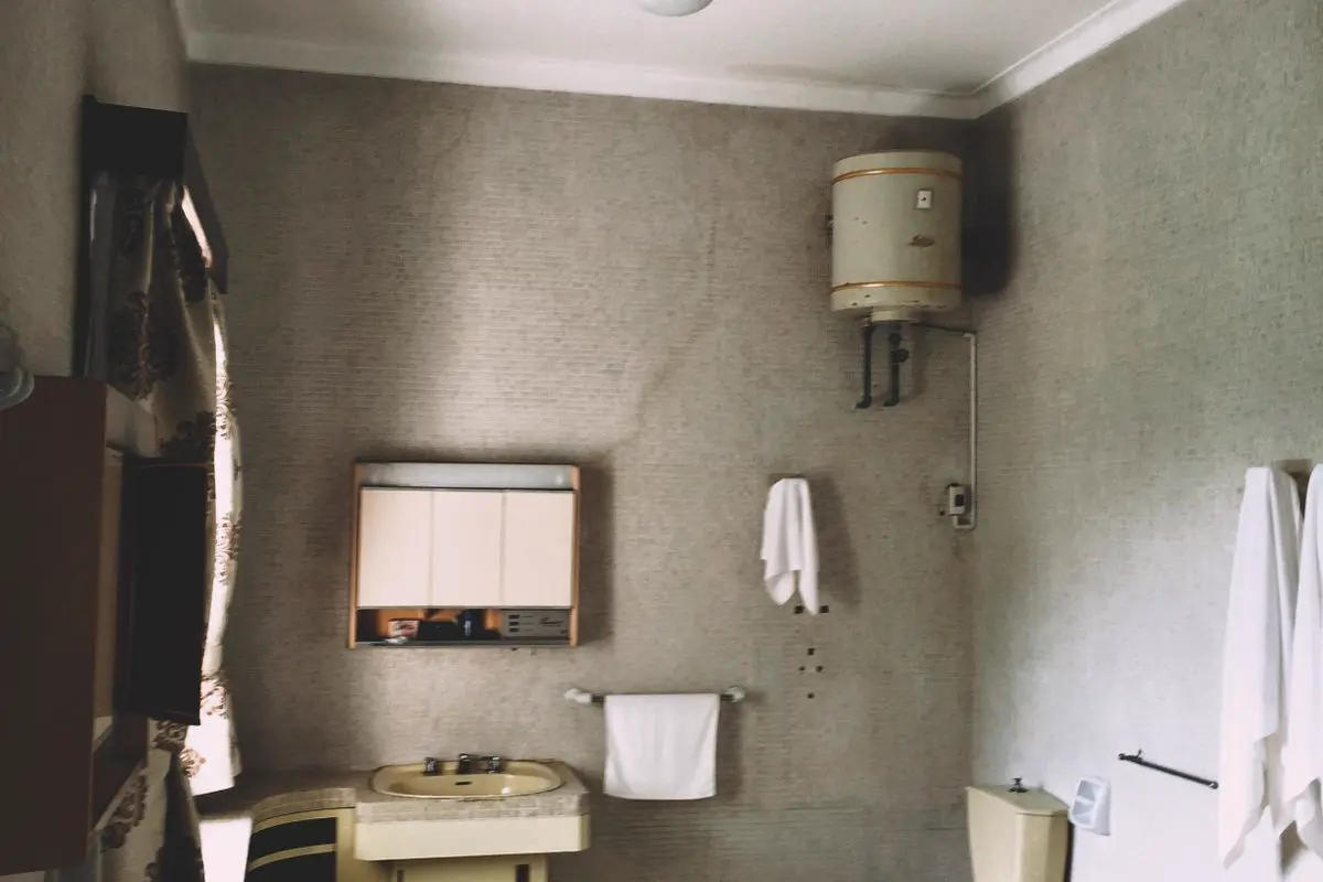 Free A vintage bathroom featuring a bathtub, sink, toilet, and cabinets in muted tones. Stock Photo